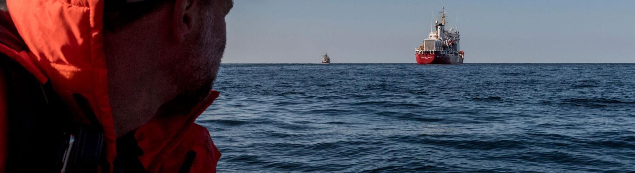 man looking at Leeway Odyssey in the distance